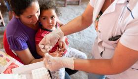 A woman gives a child a tetanus shot.