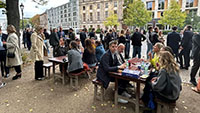 Eine Gruppe von Menschen essen Currywurst und Pommes und tauschen sich aus