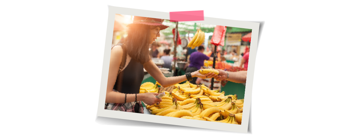 Polaroid of woman buying a banana at a market