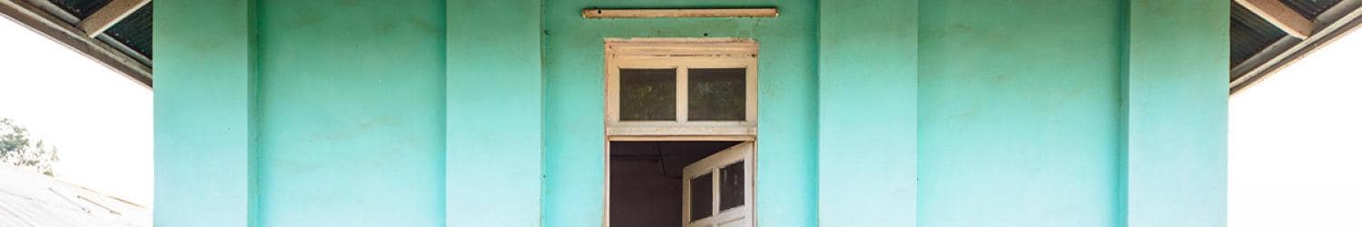 A blue building with a window on it.