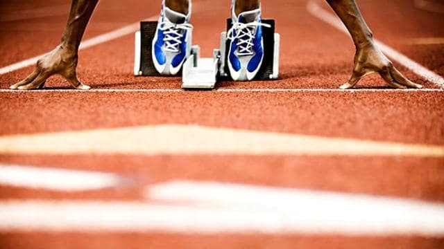 A person's feet on a running track.