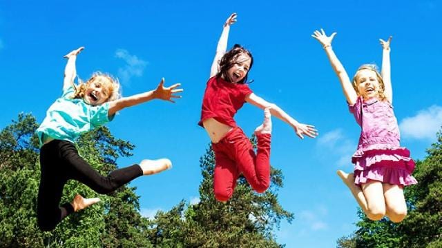 Three young girls jumping in the air.