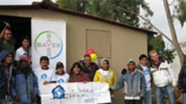 A group of people standing in front of a small building.