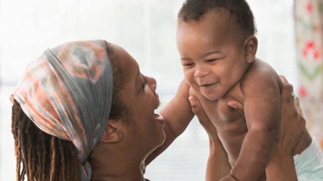 A woman holding a baby in her arms.