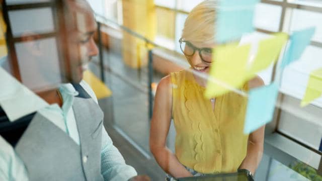 A man and woman are talking to each other in an office.