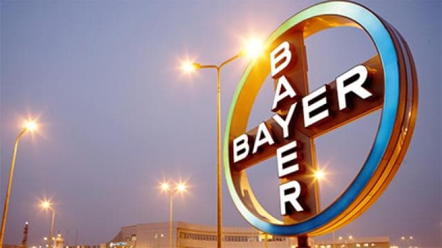 A sign for bayer in front of a building at night.