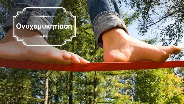 A person's feet on a red rope in the forest.