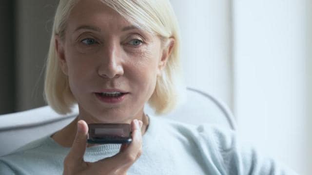 A woman is holding a cell phone in her hand.