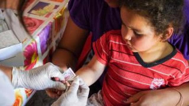 A woman is giving a child a tetanus shot.