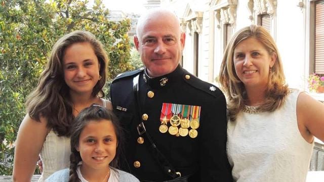 A military man and his family pose for a photo.