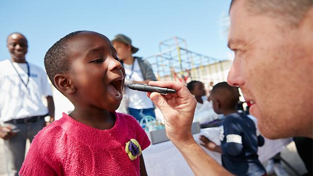 Volunteer doctor examining child