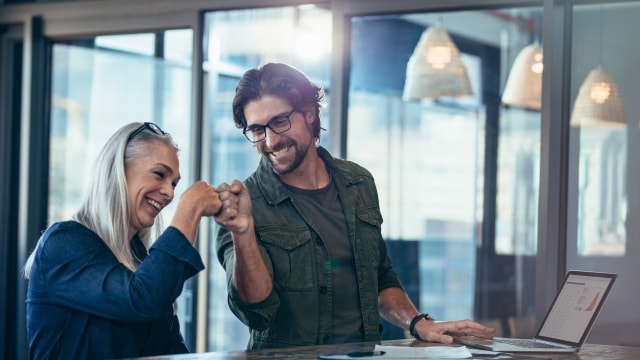 Colleagues fist bumping