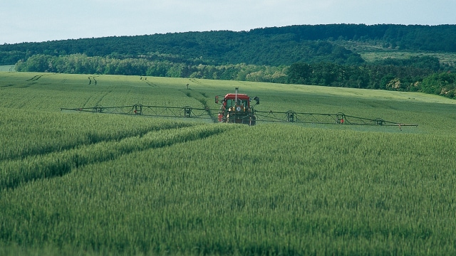 A farmer spraying glyphosate on his field. 