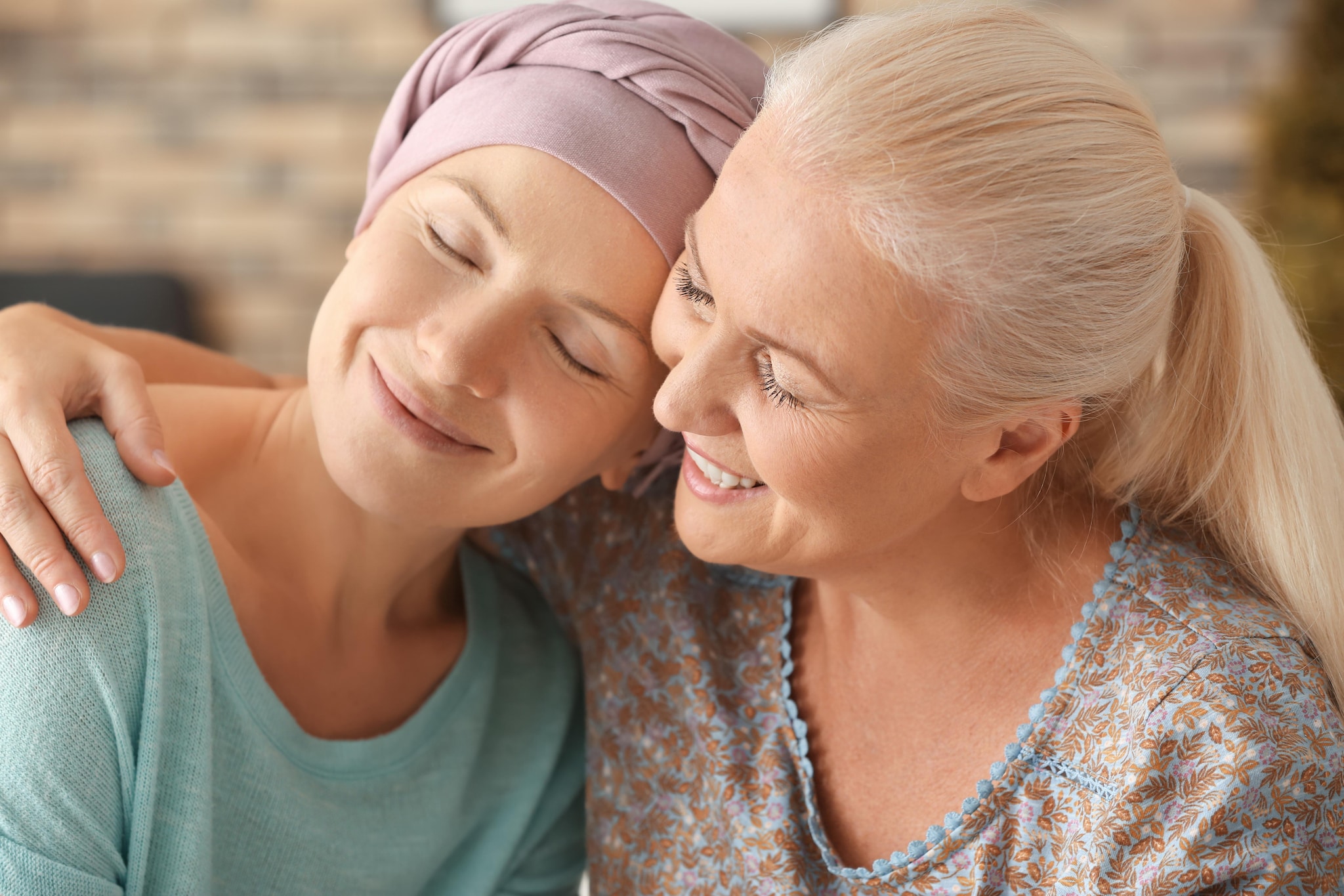 Patiente atteint d'un cancer enlacée par une femme