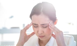 Woman holding forehead from a headache