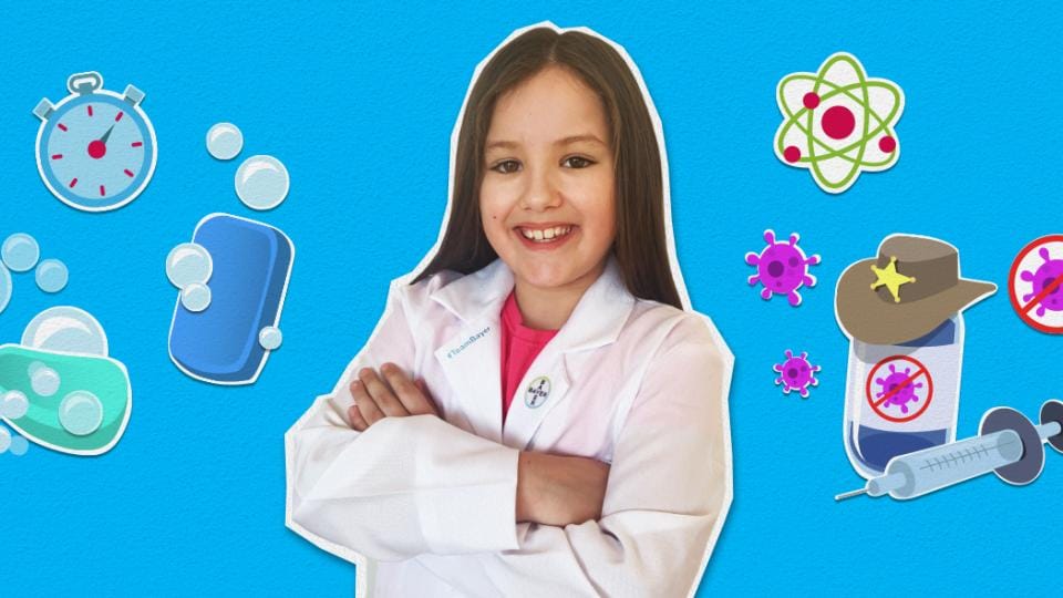 A girl in a lab coat is standing in front of a blue background.