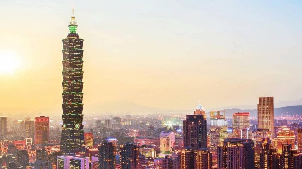 The taipei skyscraper is lit up at dusk.