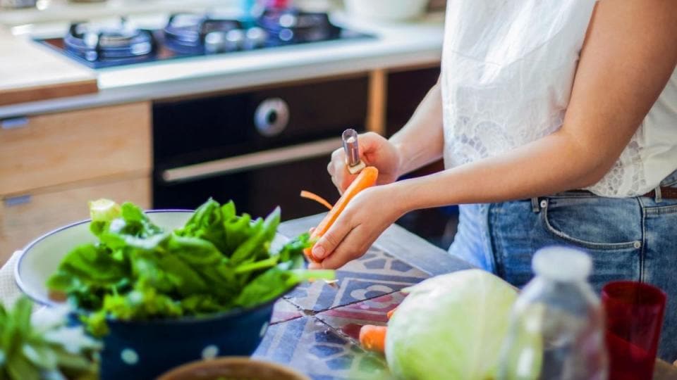 A woman is preparing vegetables in the kitchen.