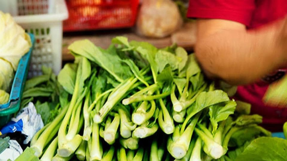 A man is preparing vegetables at a market.