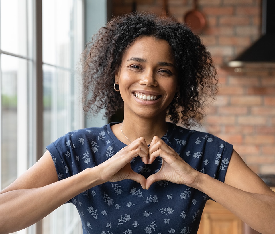 A woman putting up a heart symbol with her hands