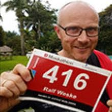 A man holds up a sign with a number.