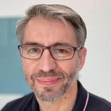 A man wearing glasses and a blue shirt.