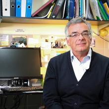 A man sits at a desk in front of a computer.