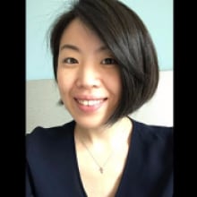 An Asian woman smiles into the camera.