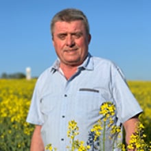 A man standing in a field of yellow flowers.