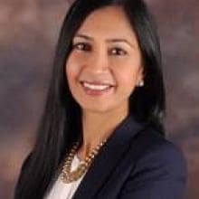 A woman in a business suit posing for a photo.